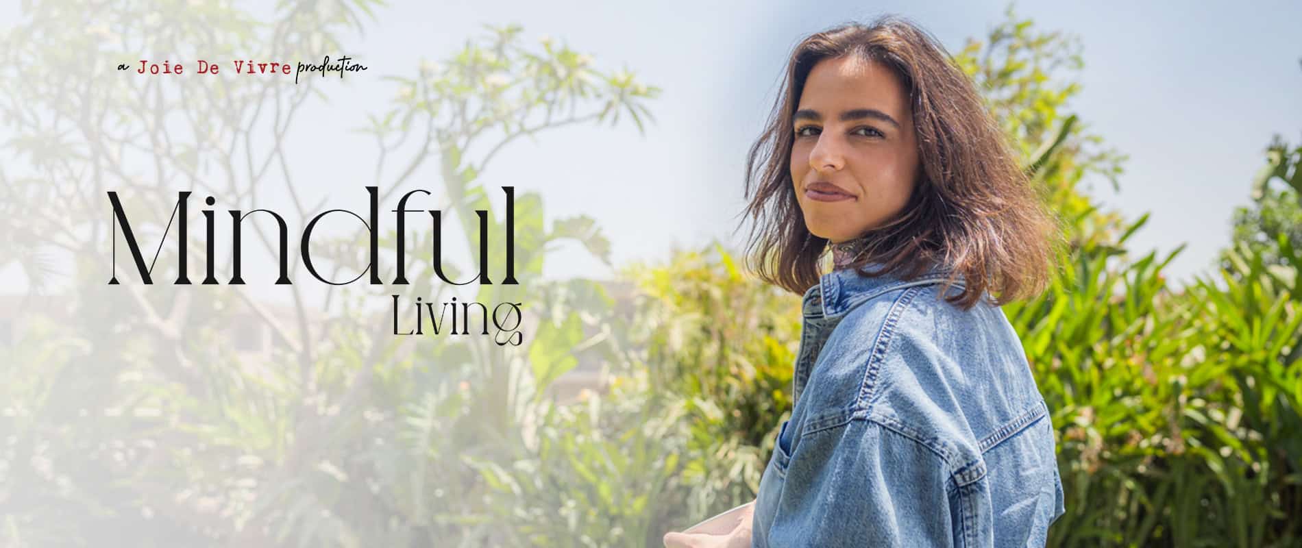 Peaceful woman with shoulder-length brown hair smiling outdoors in natural sunlight, representing mindful living, wellness, and self-care concepts.