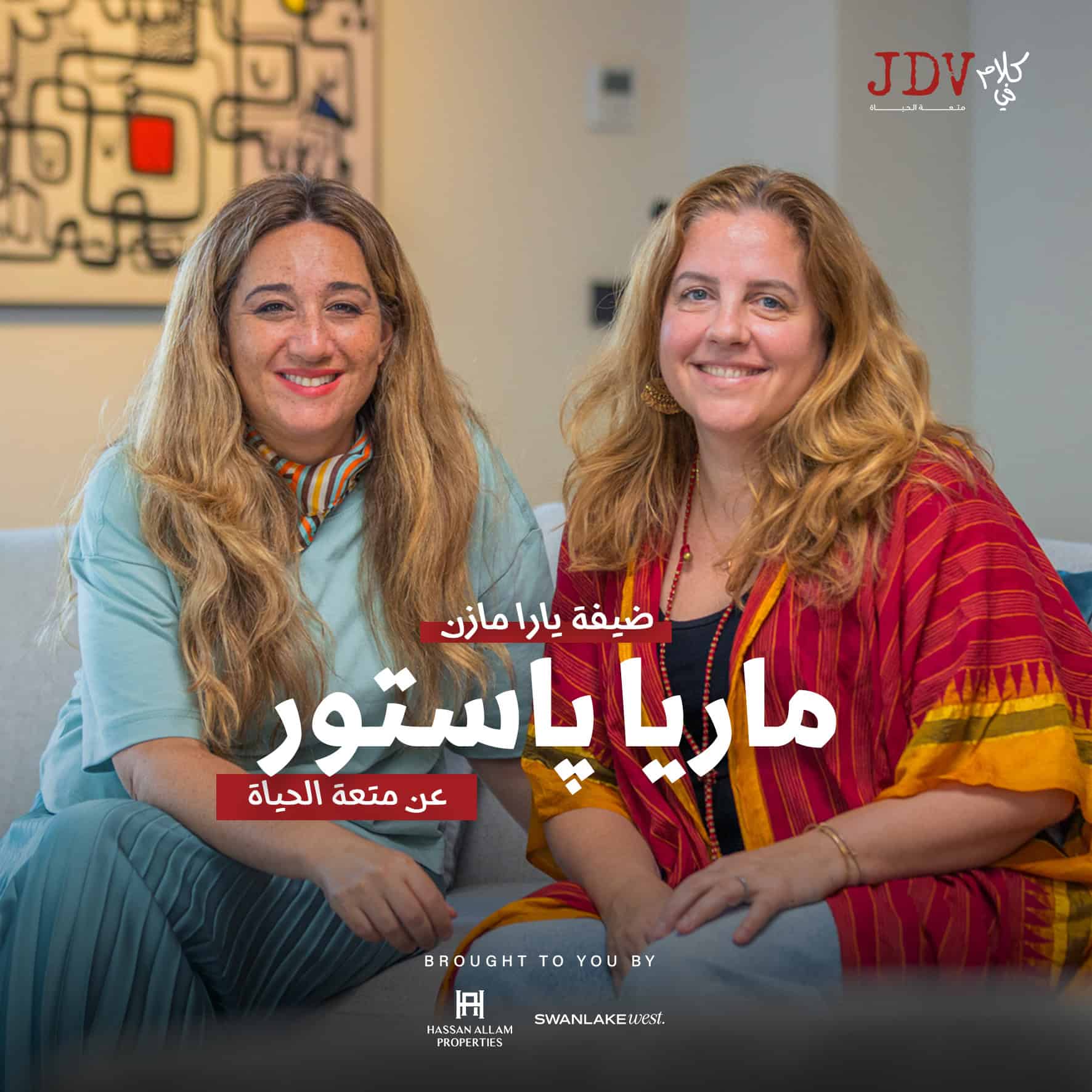 "Two women smiling happily, sitting together in a modern, well-lit interior, promoting Maria Baytor's life coaching for a meaningful life, with the JDV logo in the background.".