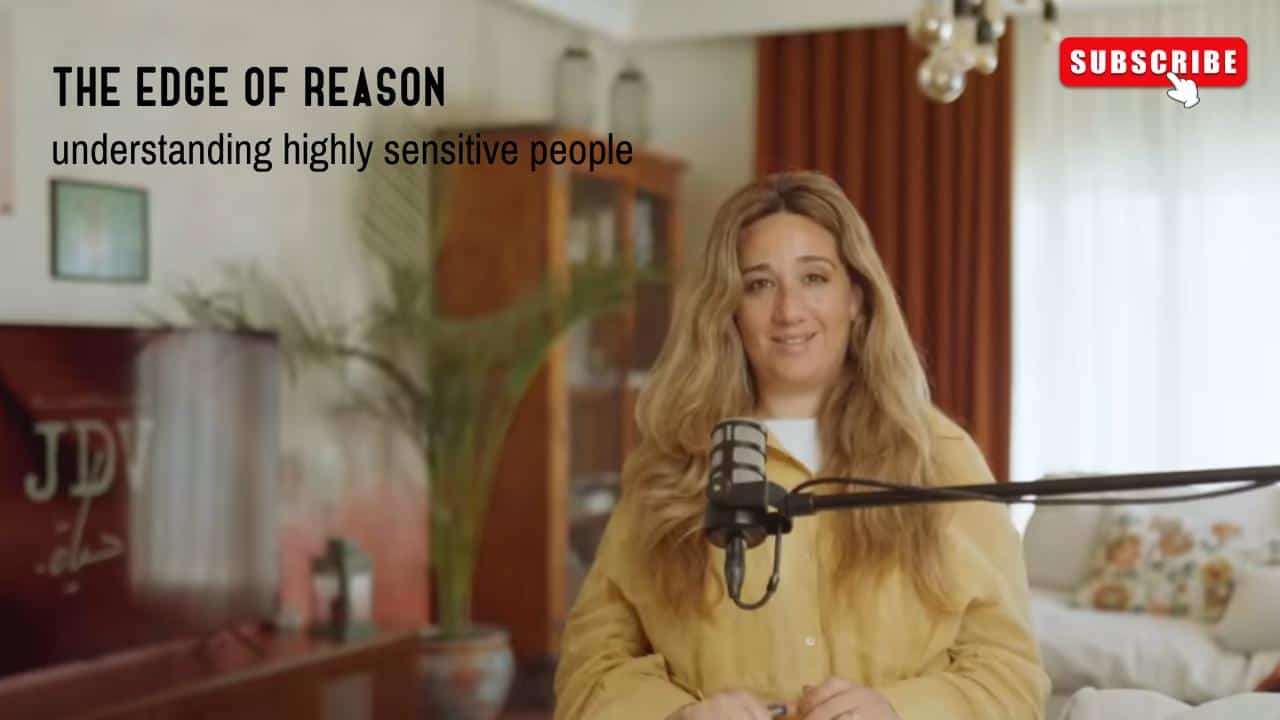 Empathetic woman recording podcast about understanding highly sensitive people in a cozy home studio with microphone and warm lighting.