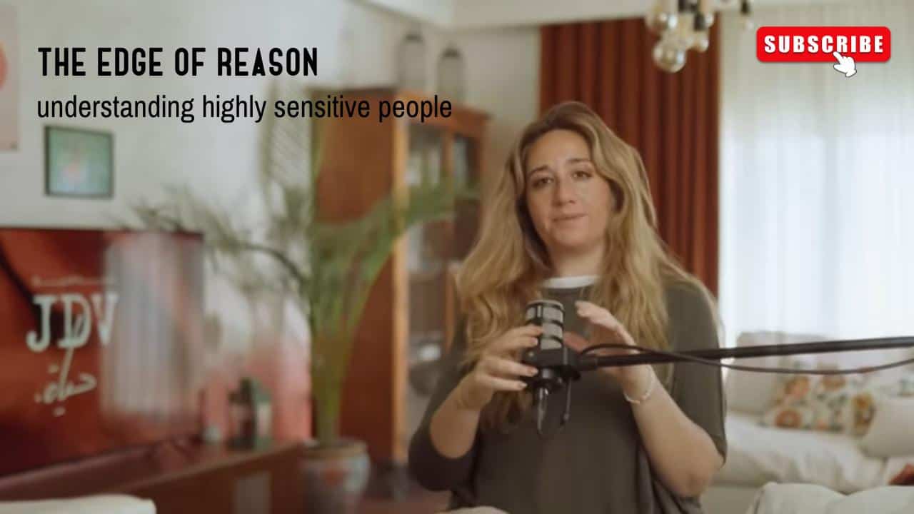 High sensitivity person recording a podcast or video in cozy home setting for mental health awareness and understanding highly sensitive people, with "JDV" branding visible.